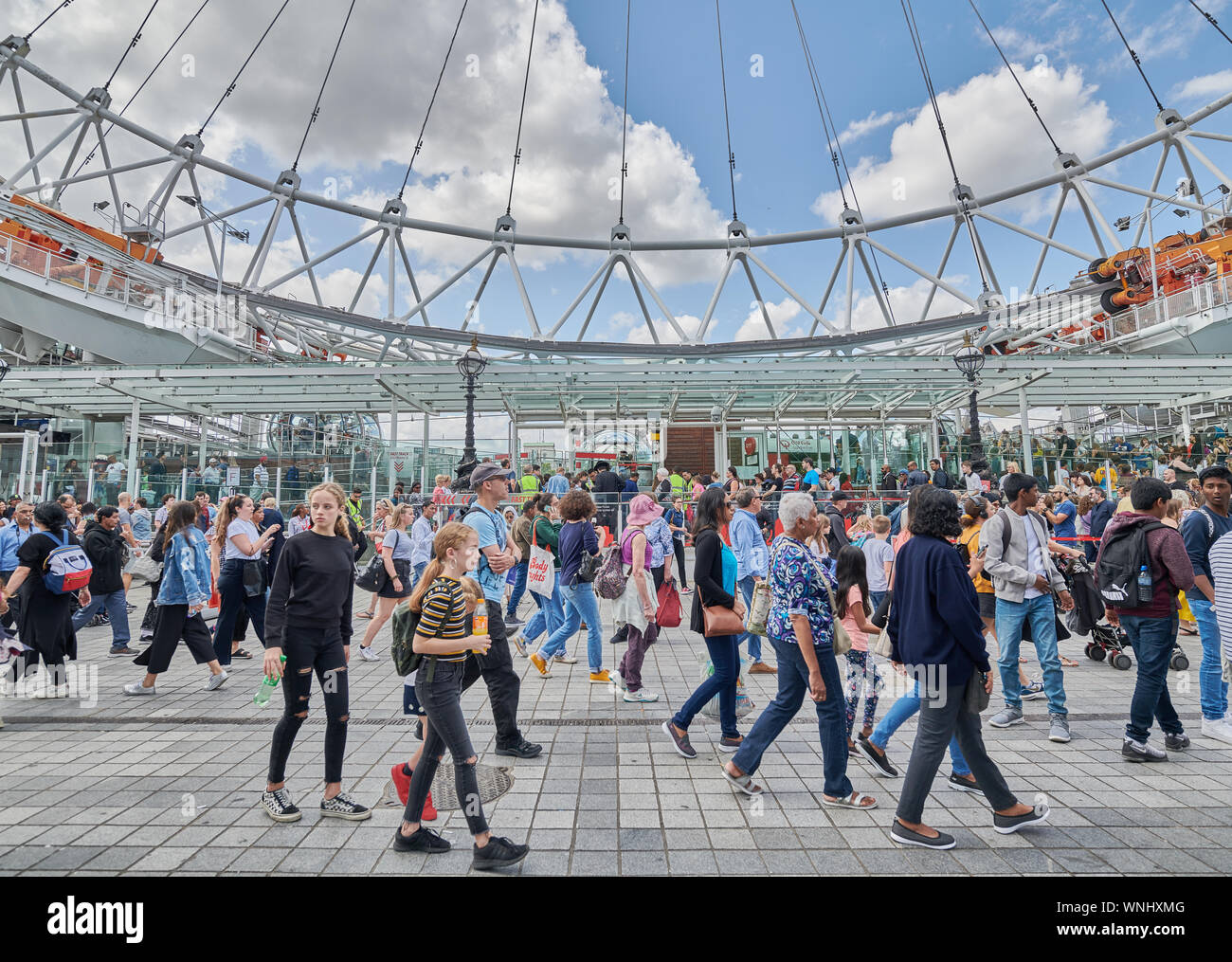 Foule de gens de différentes nationalités à l'extérieur de la grande roue London Eye, en Angleterre, un jour d'été. Banque D'Images