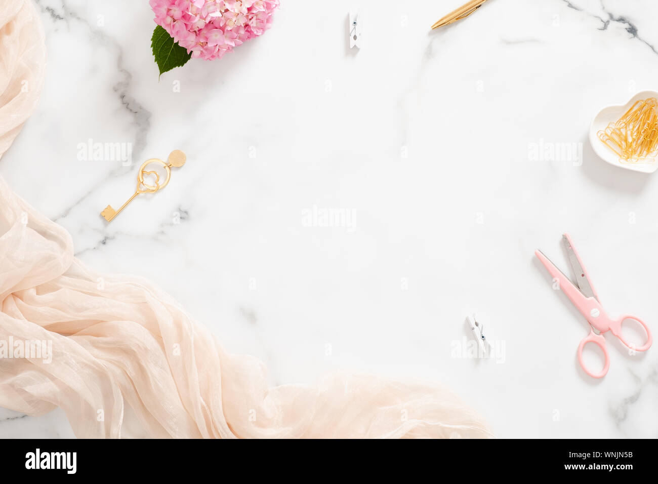 Composition élégante avec des fleurs d'hortensias rose pastel, couverture et accessoires d'or sur en arrière-plan. Mise à plat, vue du dessus beauty blogger workspac Banque D'Images