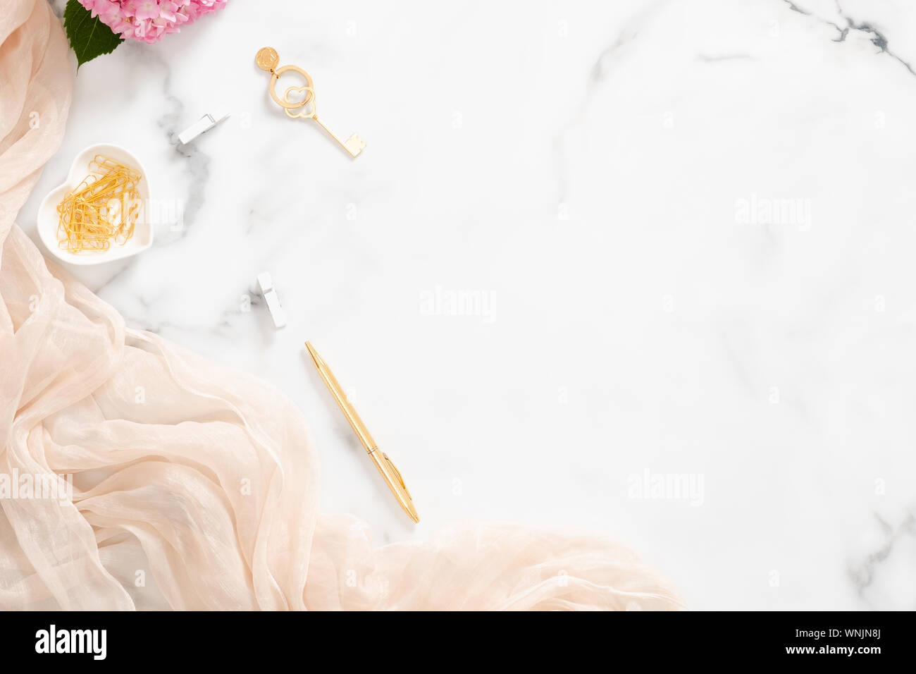 Composition élégante avec des fleurs d'hortensias rose pastel, couverture et accessoires d'or sur en arrière-plan. Mise à plat, vue du dessus beauty blogger workspac Banque D'Images