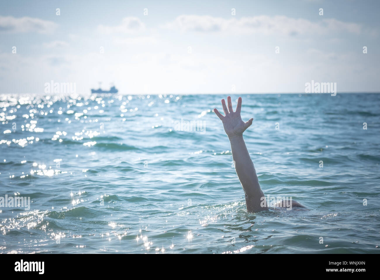 Seule main d'homme qui se noie dans la mer de demander de l'aide. sortant de l'eau Banque D'Images