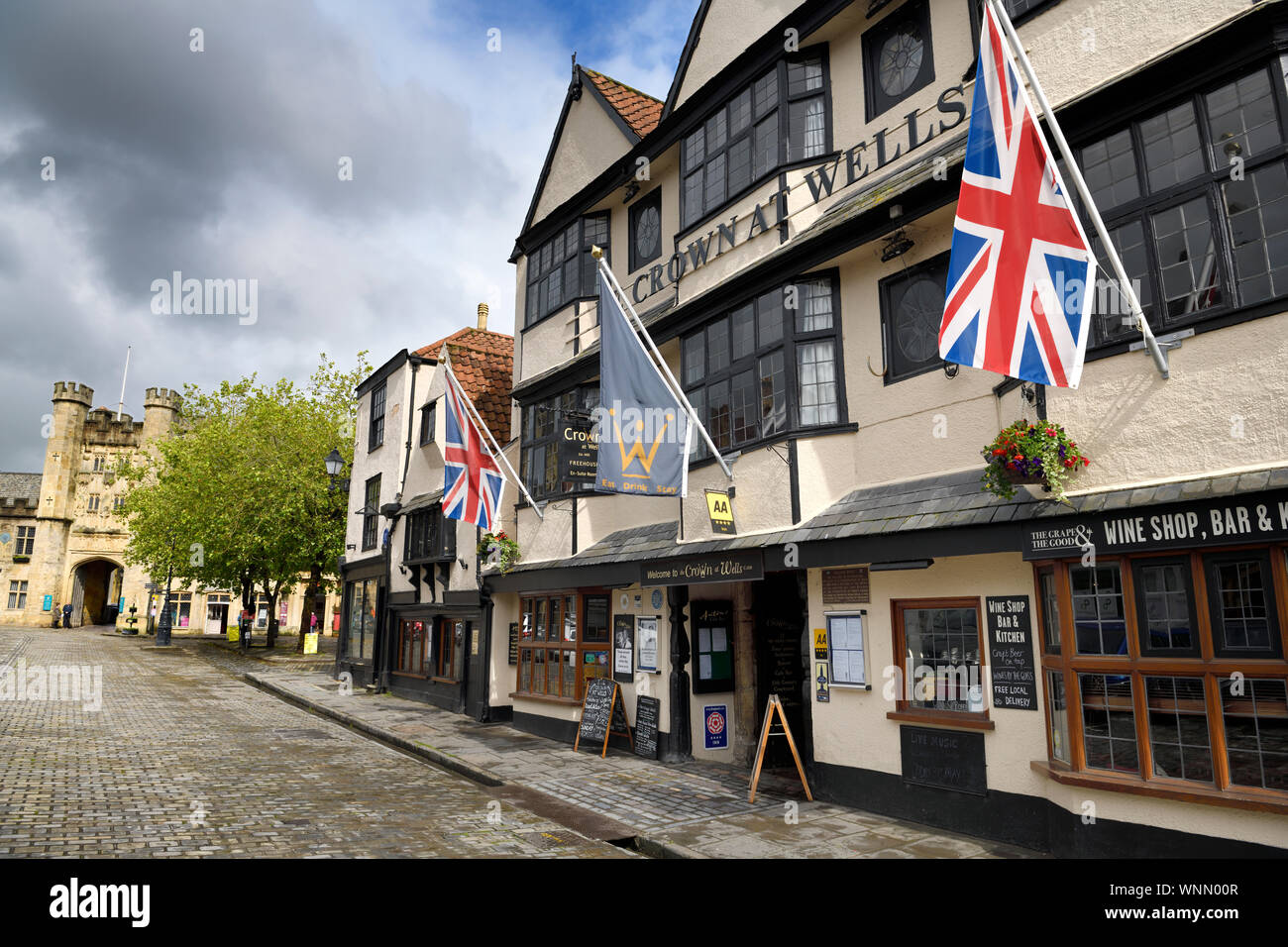 Pubs sur Market Place centre ville de Wells l'Angleterre et l'arche de pierre médiéval appelé évêque's Eye menant à l'Évêché Banque D'Images