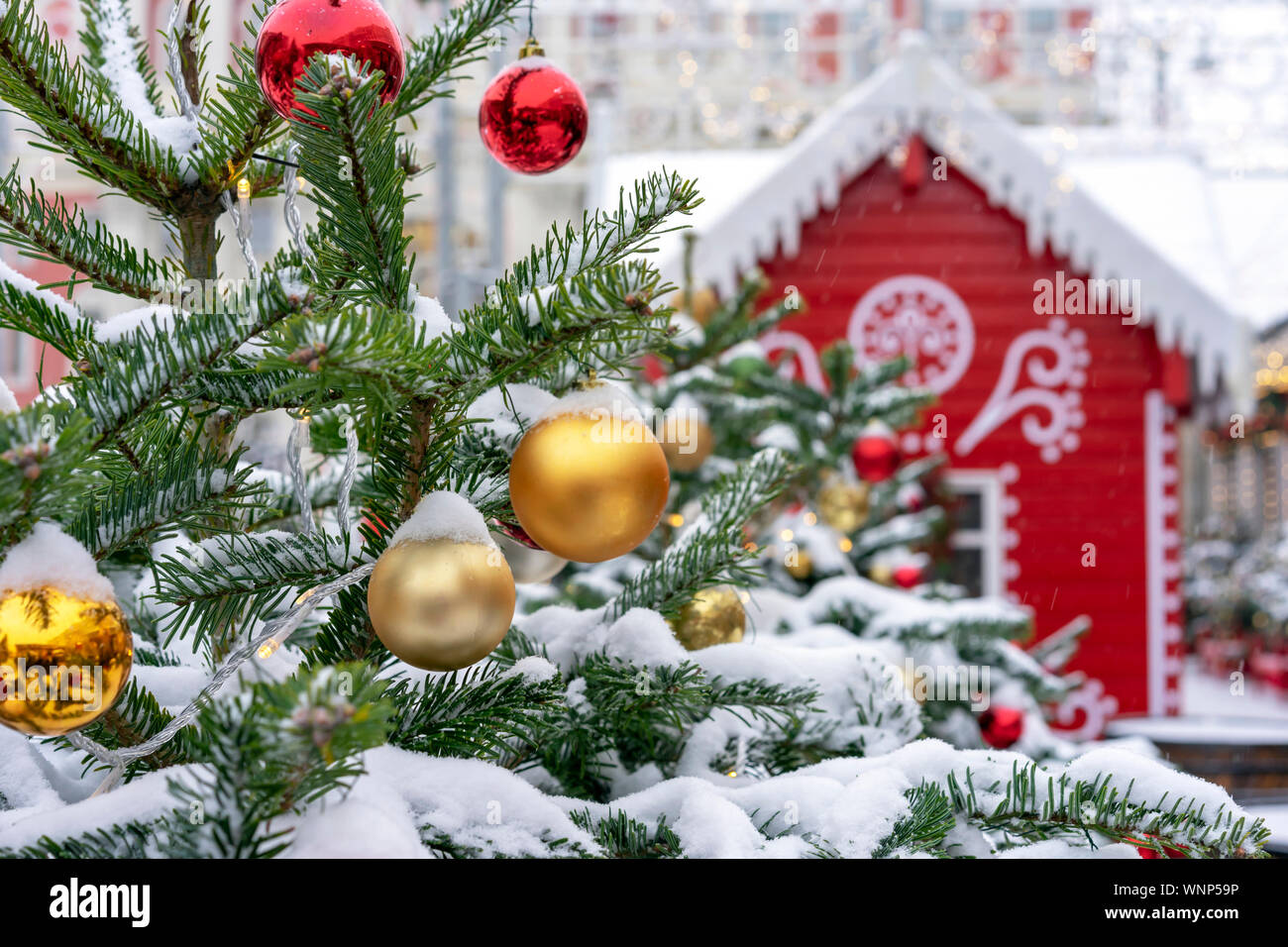 Arbre de Noël décoré sur l'arrière-plan d'une maison de fées rouge. Banque D'Images