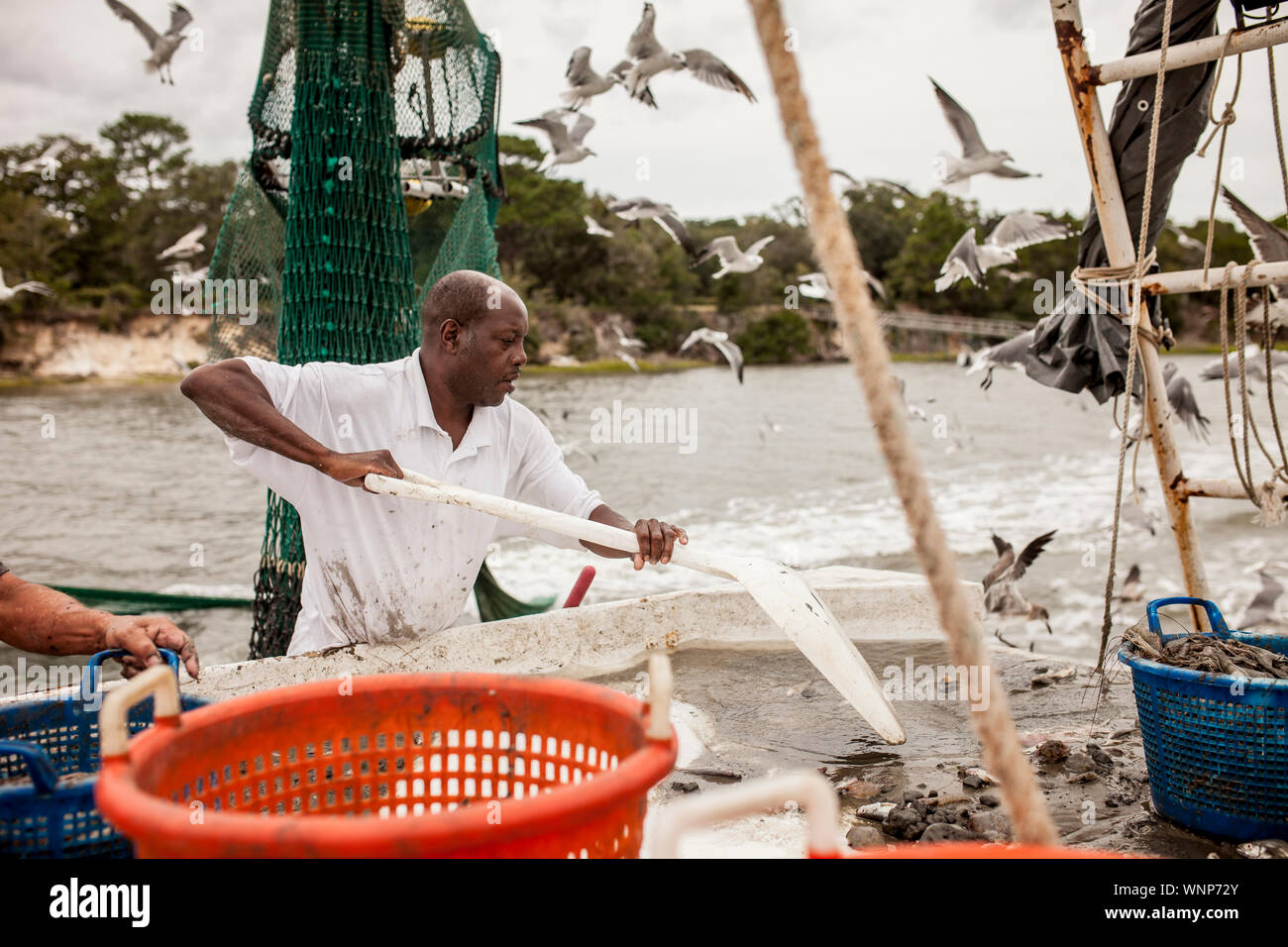 African American tri pêcheur s'accrocher sur le pont d'un bateau de pêche. Banque D'Images