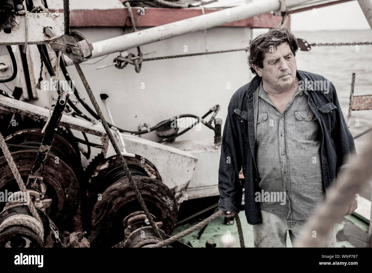 Le capitaine d'un navire de pêche commerciale se tient sur le pont. Banque D'Images