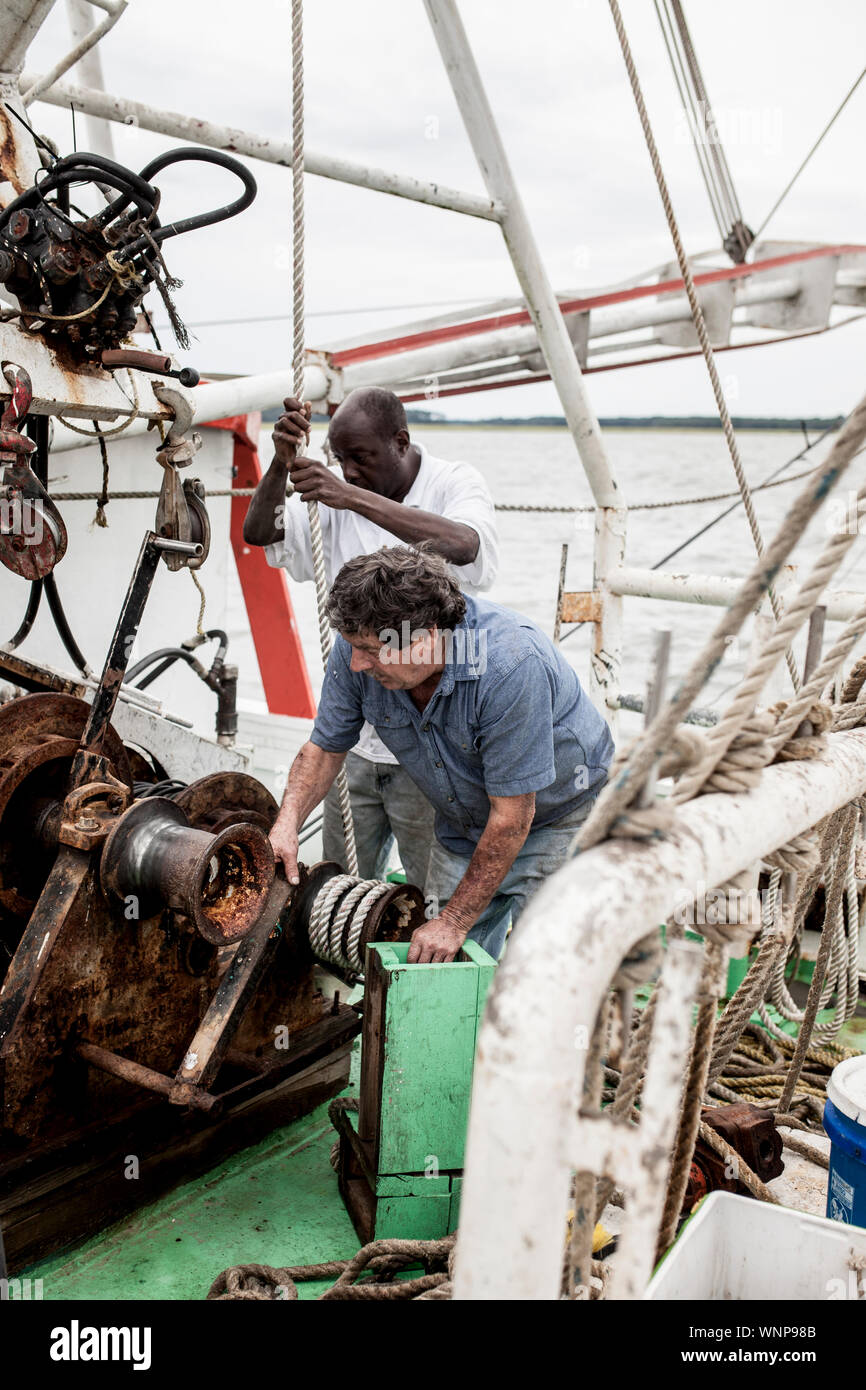 Les pêcheurs commerciaux travaillant sur le pont d'un bateau de la crevette en Caroline du Sud Banque D'Images