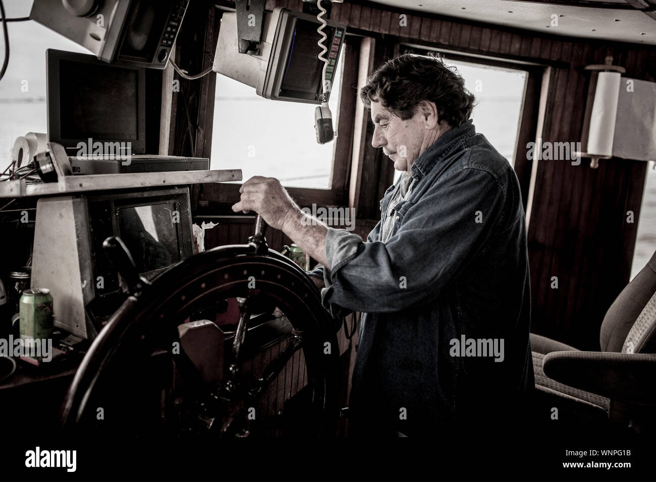 Le capitaine des navires au volant d'un bateau de pêche commerciale. Banque D'Images