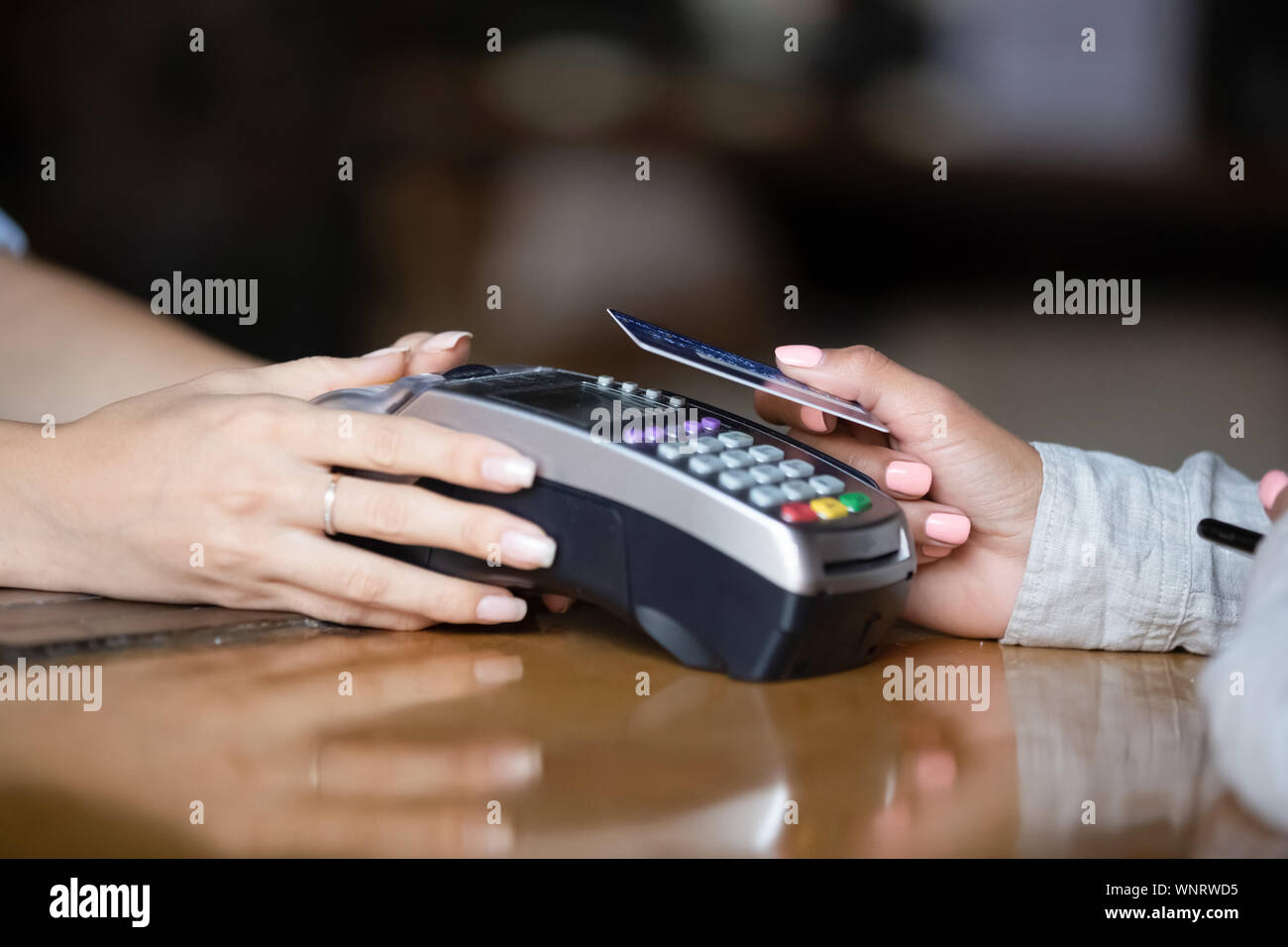 Close up femme de payer par carte sans contact, le terminal sur comptoir bar Banque D'Images