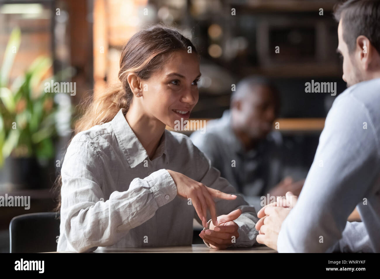 Mixed Race woman smiling attractive à discuter avec l'homme dans coffeehouse Banque D'Images