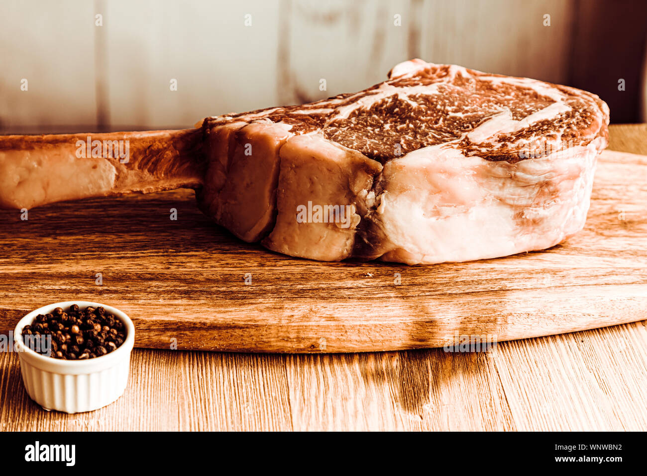 De sec matières tomahawk Pavé de boeuf sur planche de bois et le poivre Banque D'Images