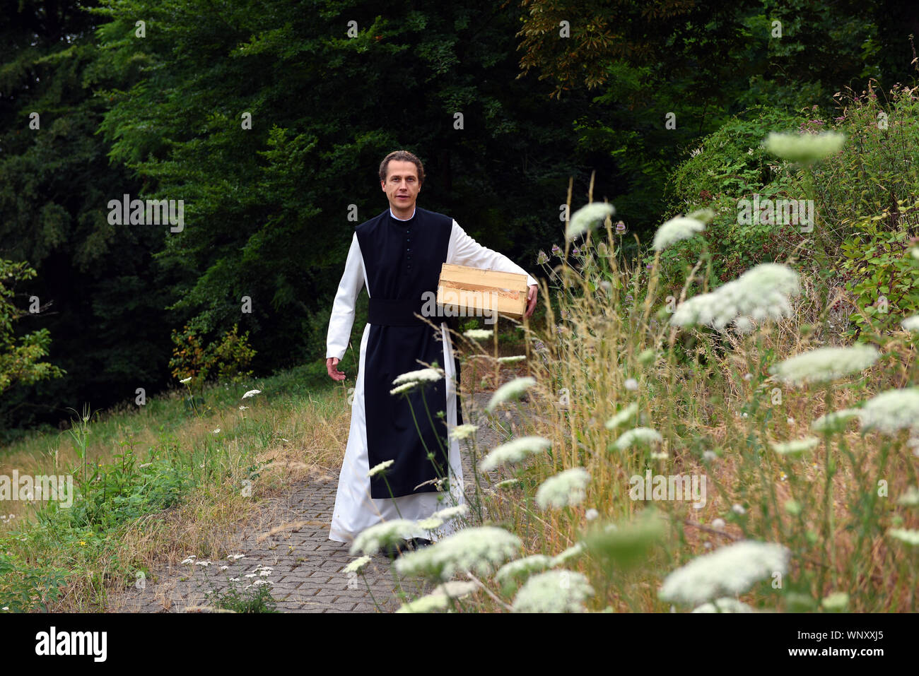04 septembre 2019, Bochum, Rhénanie du Nord-Westphalie : Père Justinus promenades dans le jardin du monastère cistercien dans le district de Stiepel. Dans sa propre production, il produit un haut pourcentage de gin et l'appelle "onatic Dry Gin'. Les herbes qu'il a besoin sont plantées et récoltées dans le jardin du monastère. Il obtient le genévrier de Toscane et le grain d'où l'alcool est obtenu qu'il obtient de l'abbaye de Heiligenkreuz mère dans la forêt viennoise. Dans le monastère lui-même il n'est pas autorisé à brûler de gin, parce qu'il n'a pas de droits de distillation. Pour ce qu'il conduit à un producteur Banque D'Images