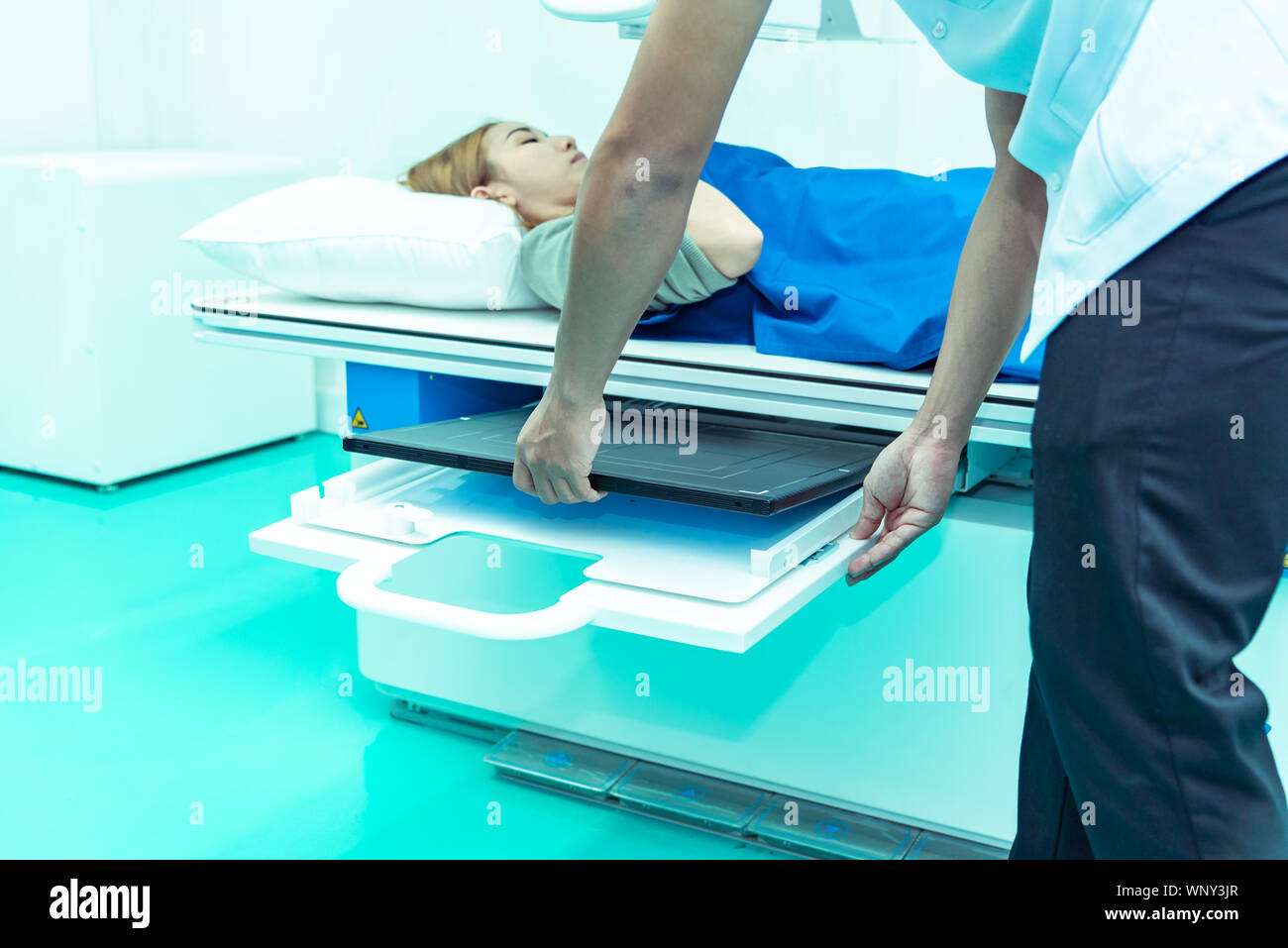 Concept ,médecine médecin radiologue Technicien mâle avec collègue mise en place de la machine pour prendre female patient in x-ray prix Banque D'Images