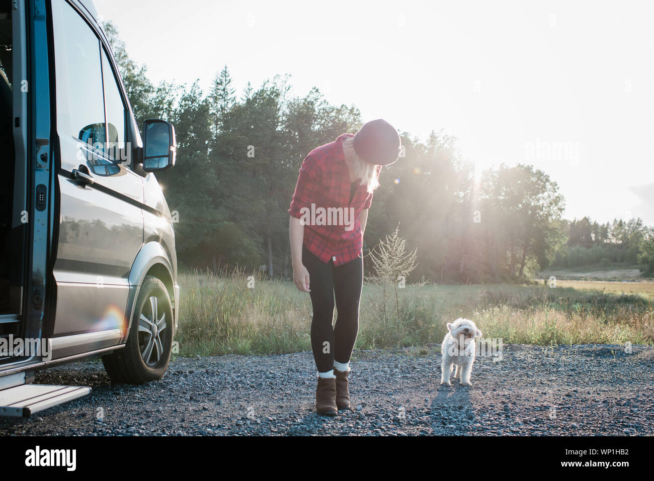Femme marche avec son chien tout en camping dans un camping-car en été Banque D'Images