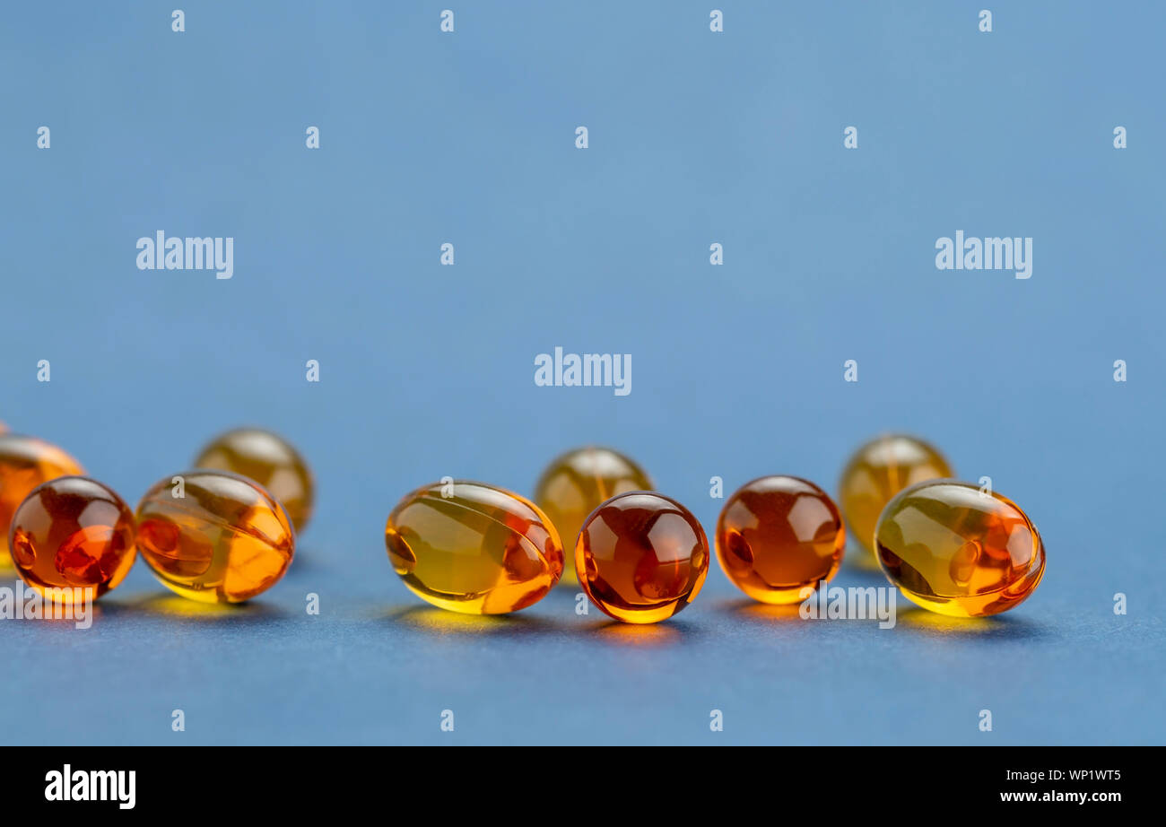 Close up of Vitamin D3 Omega 3 capsules d'huile de poisson sur bluebackground Banque D'Images