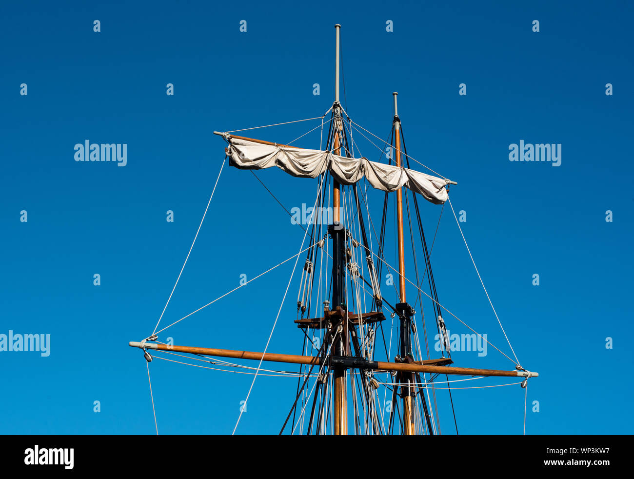 Deux mâts de bois de grands bateaux ou voiliers avec bras de cour ou spar et truquage contre un fond de ciel bleu ensoleillé Banque D'Images