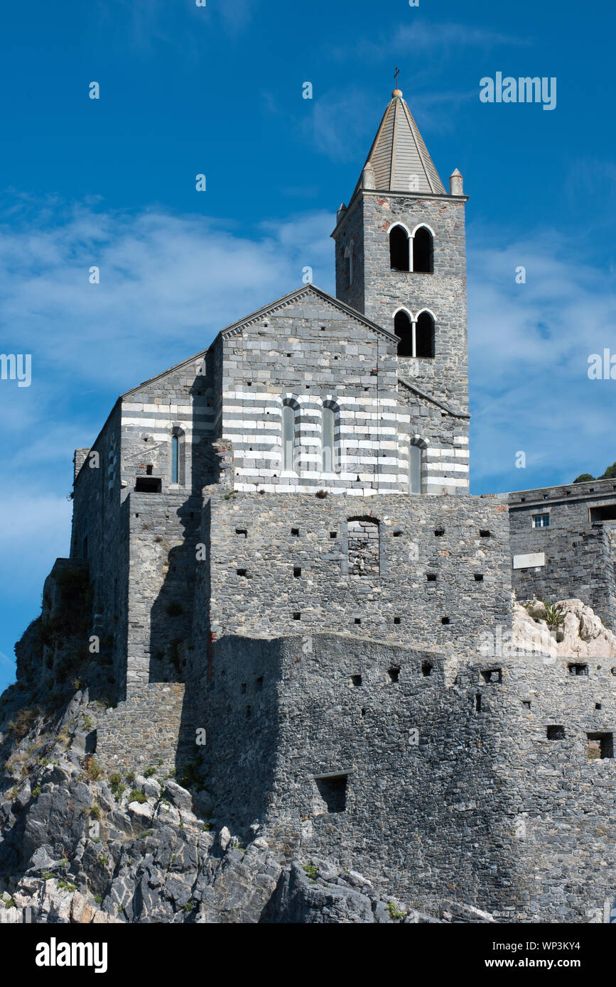 Portrait de l'historique église Saint Pierre à Portovenere, ligurie, italie perché sur les rochers contre un ciel bleu ensoleillé Banque D'Images