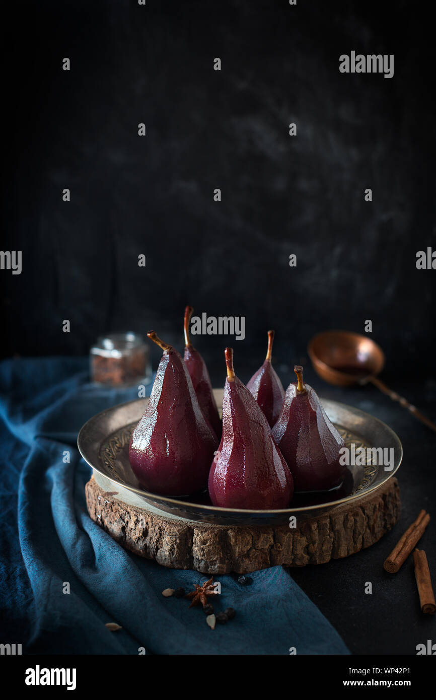 Poires pochées au vin rouge à la cannelle et anis Banque D'Images