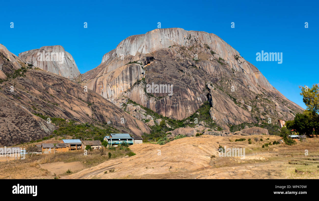 Petit village dans le sud-ouest de Madagascar highlands typique construite en brique avec des maisons de chaume de la culture du riz et les montagnes Banque D'Images