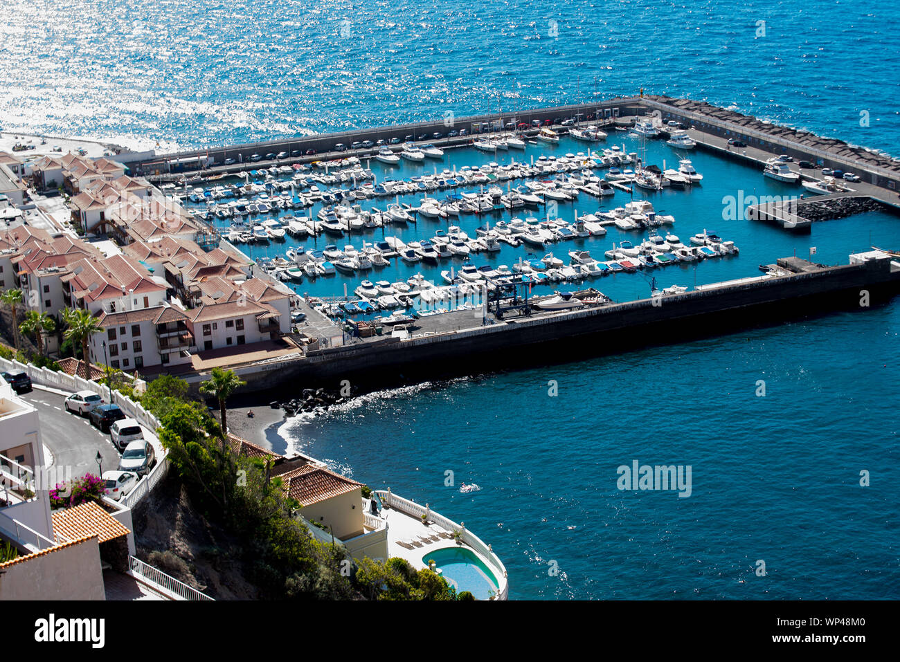 Vue aérienne du port de Los Gigantes, Ténérife, îles Canaries. La marina est pleine de bateaux et le soleil brille Banque D'Images