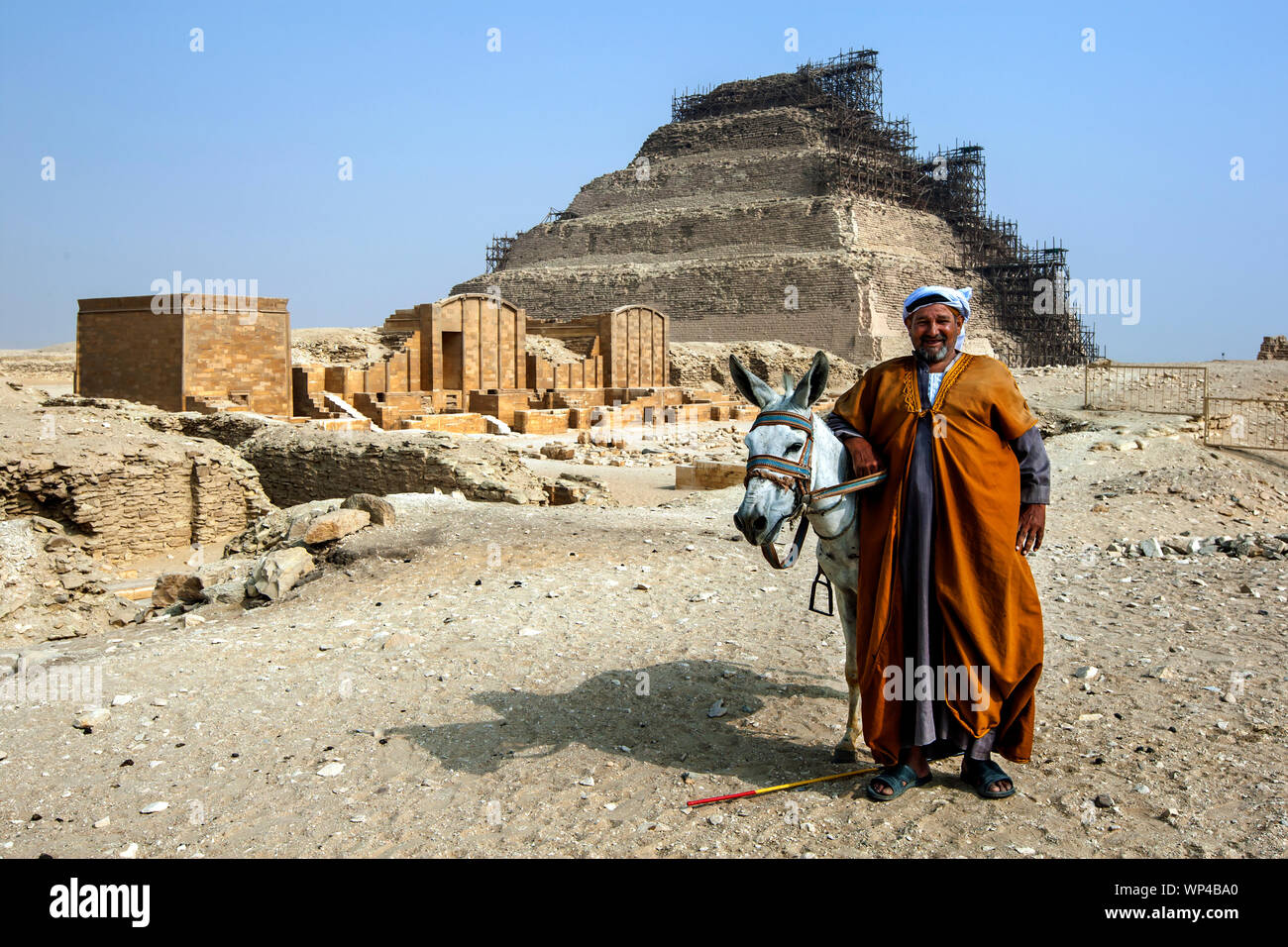 Un homme et son âne, se tenir en face de la pyramide et la Cour de Heb Sed à Saqqara en Égypte. Banque D'Images