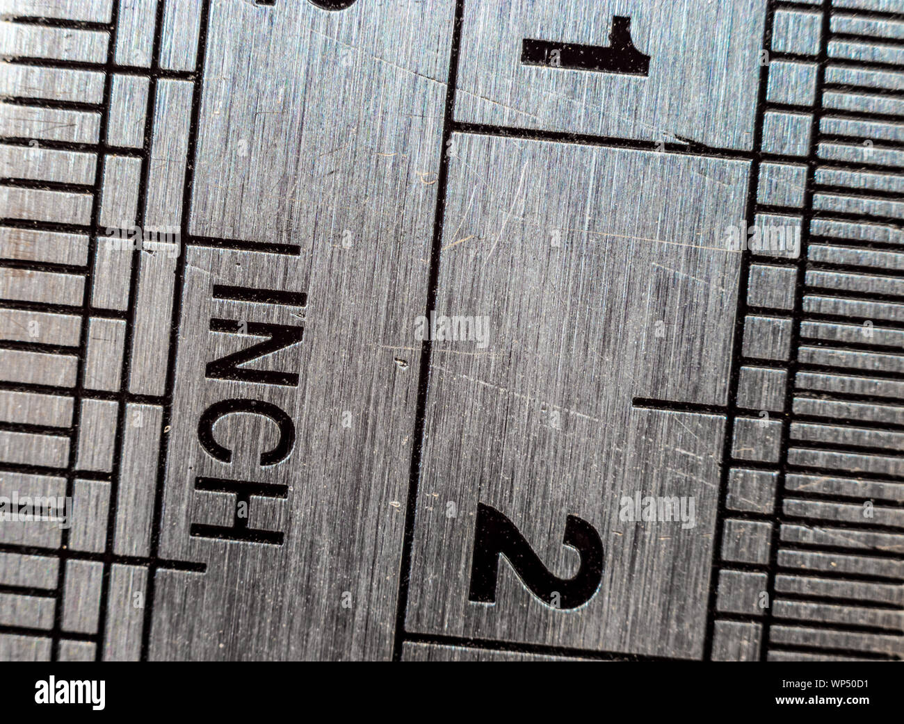 Macro close-up d'une règle en acier inoxydable avec système métrique et la mesure des échelles : Pouces et Millimètres. Banque D'Images
