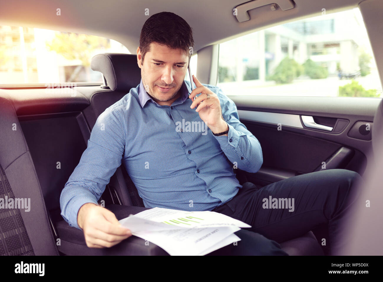 Happy smiling business man talking on phone assis dans un taxi Banque D'Images
