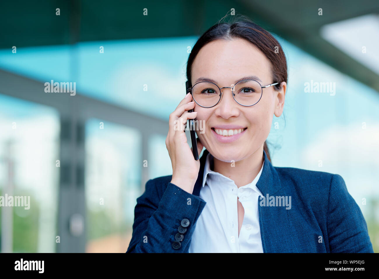 Jeune femme élégante avec dents sourire holding smartphone par l'oreille Banque D'Images