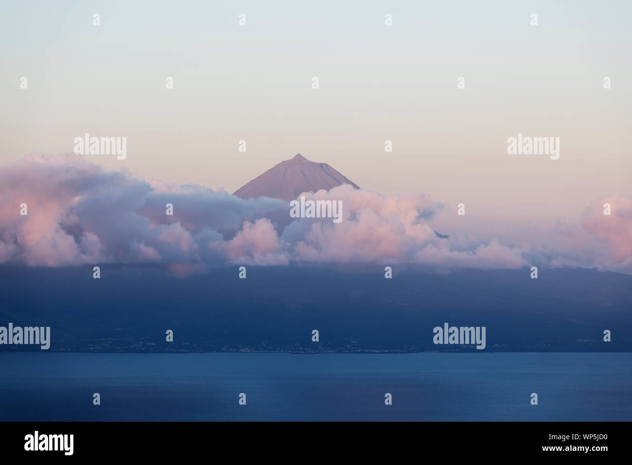 Le mont Pico, Ponta do Pico avec couche de nuages à un beau lever de soleil vu de l'île de São Jorge Banque D'Images