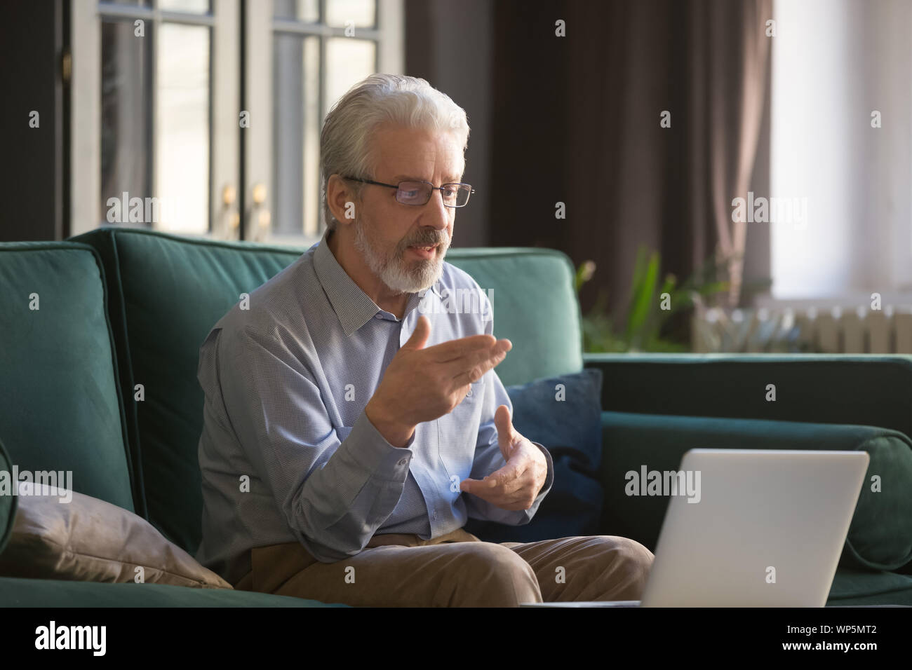 Homme mûr à l'aide d'une connexion informatique ayant appel vidéo Banque D'Images