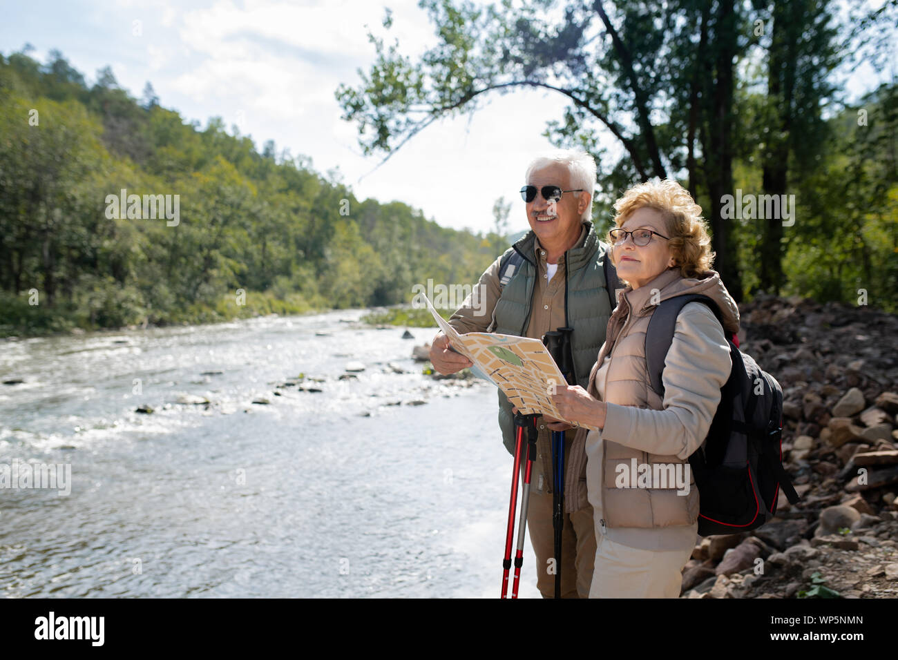 Senior active mari et femme avec des sacs à dos et la carte pendant le trekking voyage Banque D'Images