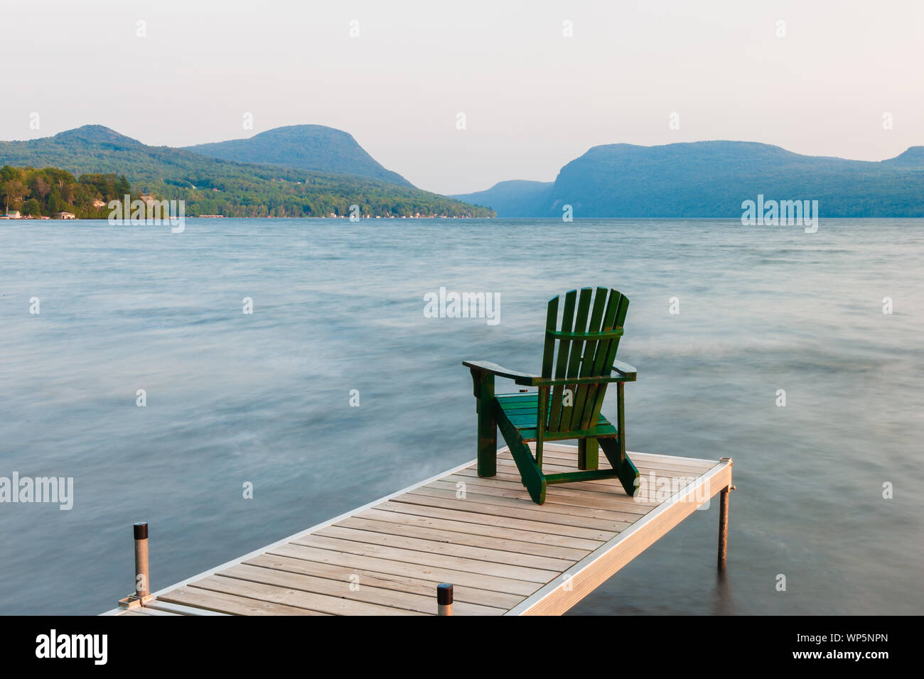 Chaise Adirondack sur le bout d'un quai sur le lac Willoughby, New York, USA Banque D'Images