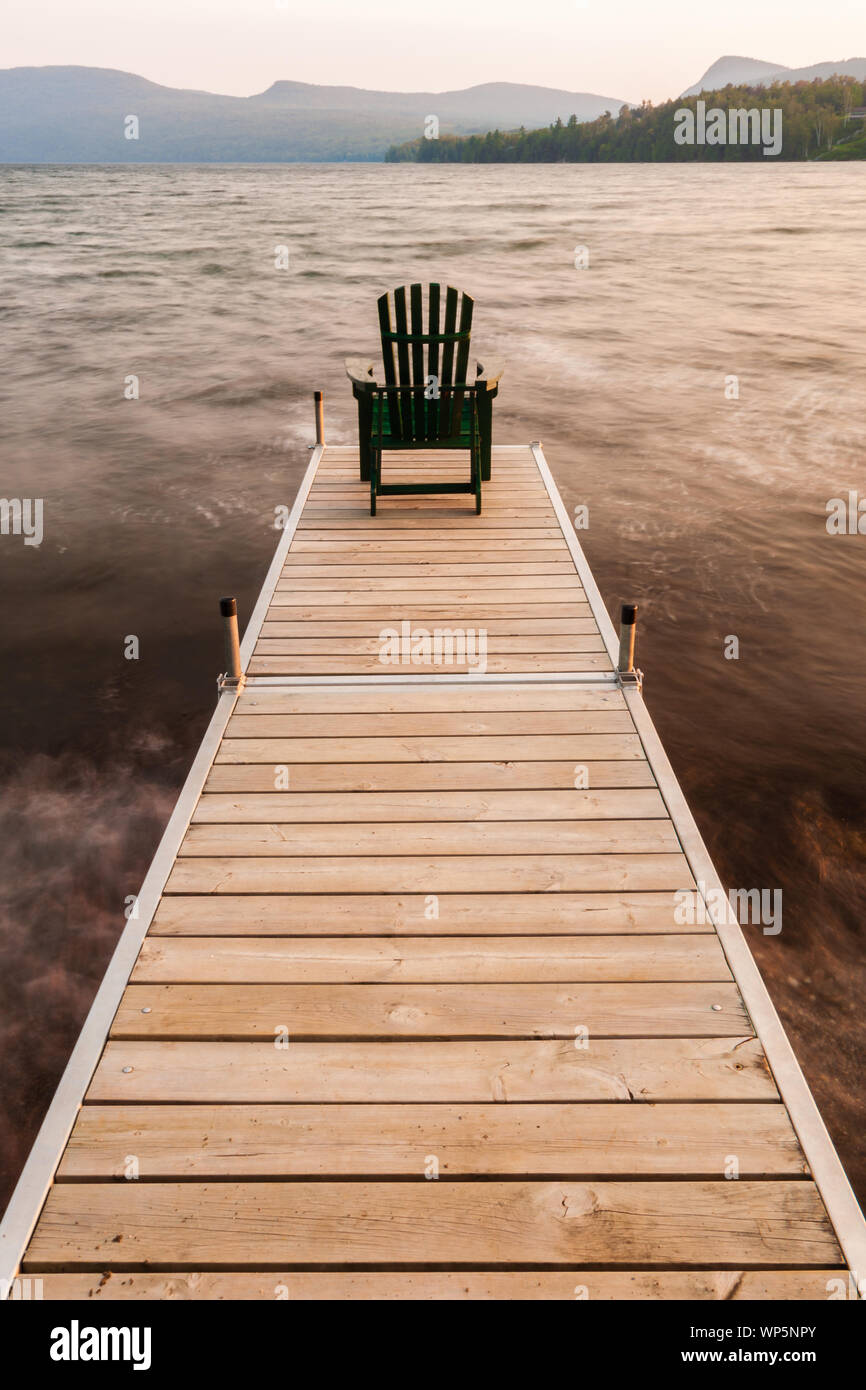 Chaise Adirondack sur le bout d'un quai sur le lac Willoughby, New York, USA Banque D'Images