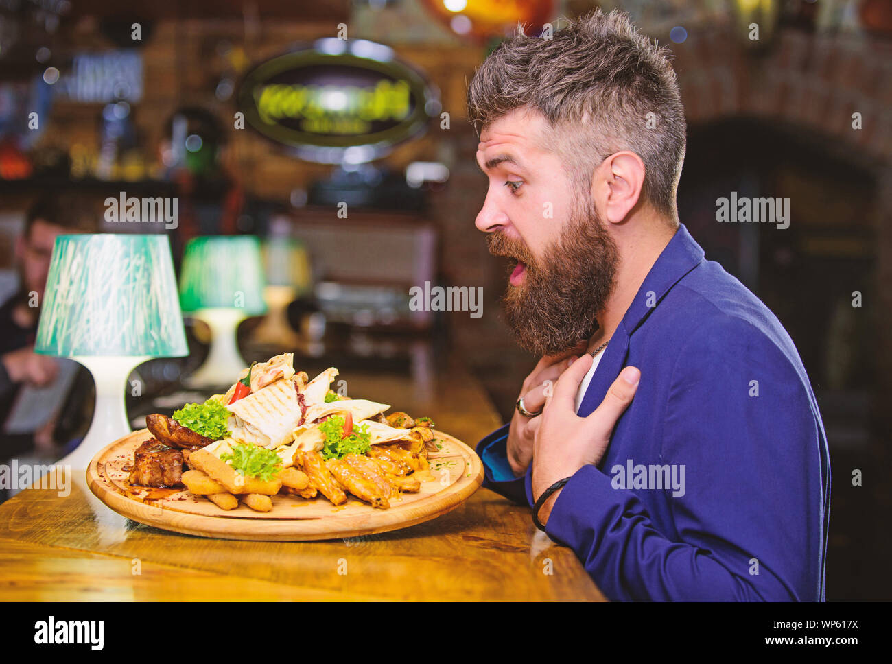 L'homme a reçu de pommes de terre frites repas avec les bâtonnets de poisson viande. Il méritent de délicieux repas. Profitez de votre repas. Des calories. Vous pourrez vous détendre après une dure journée. La nourriture délicieuse. Woman costume formel s'asseoir au restaurant. Banque D'Images