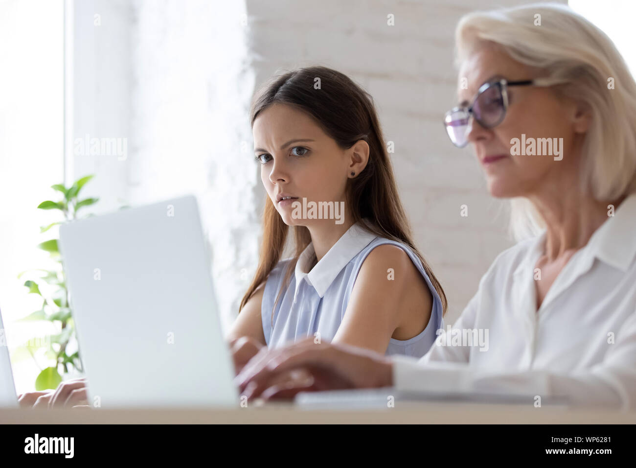 Choqué employée d'oeil étonné à l'ordinateur portable de collaborateur peeping Banque D'Images