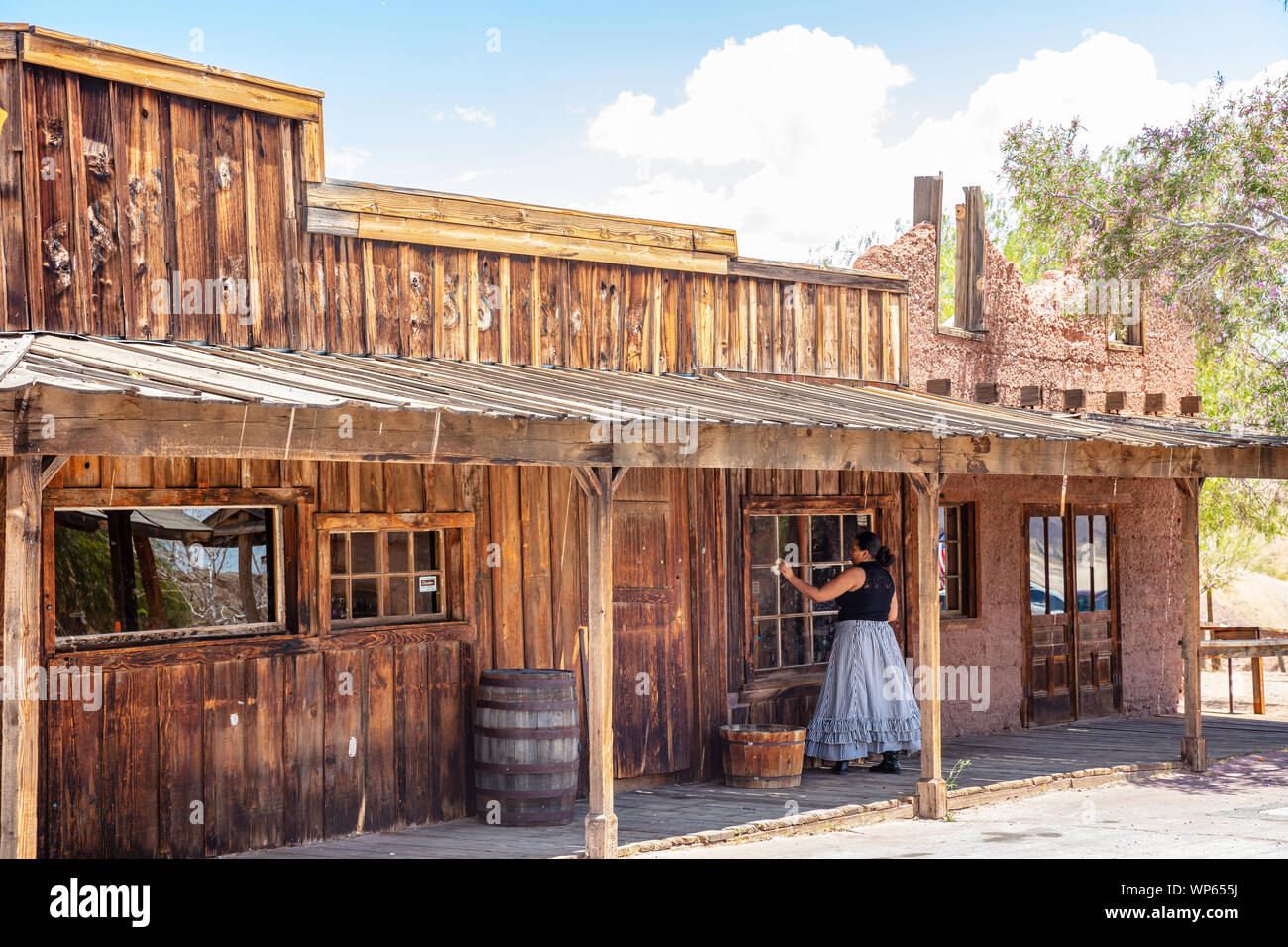 Calico ghost town Californie, USA. 29 mai, 2019. Femme en robe retro nettoyage de la fenêtre en verre dans une journée de printemps ensoleillée Banque D'Images