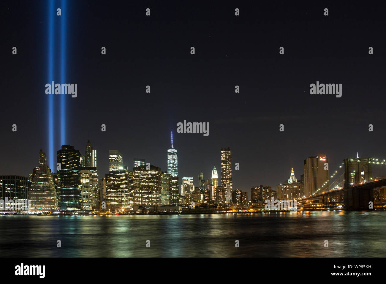 Manhattan skyline et la Tour de la liberté la nuit, vu de Brooklyn. Banque D'Images