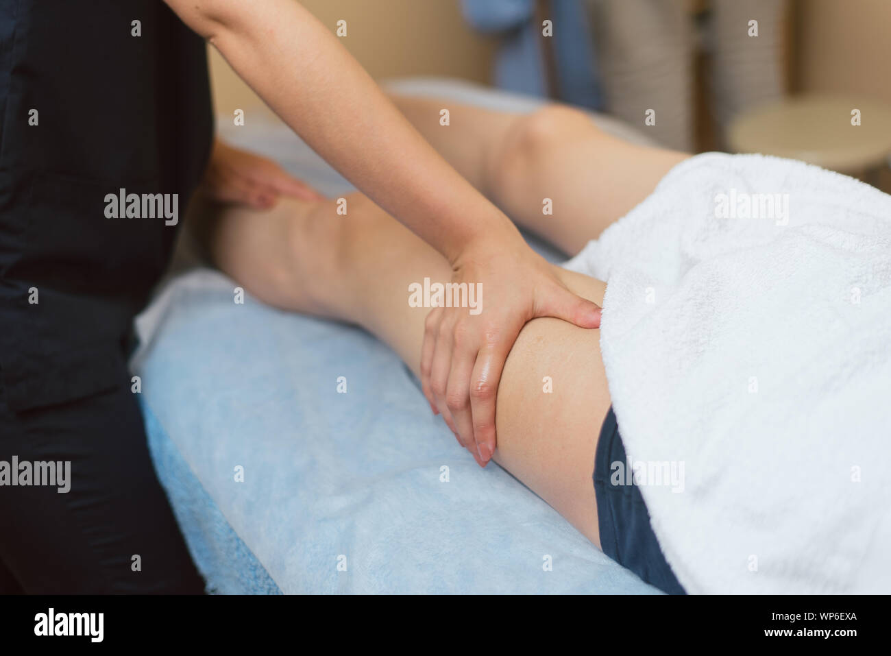 Masseur massage faire le genou pour le jeune homme. Le médecin des massages la jambe pour le traitement. Banque D'Images