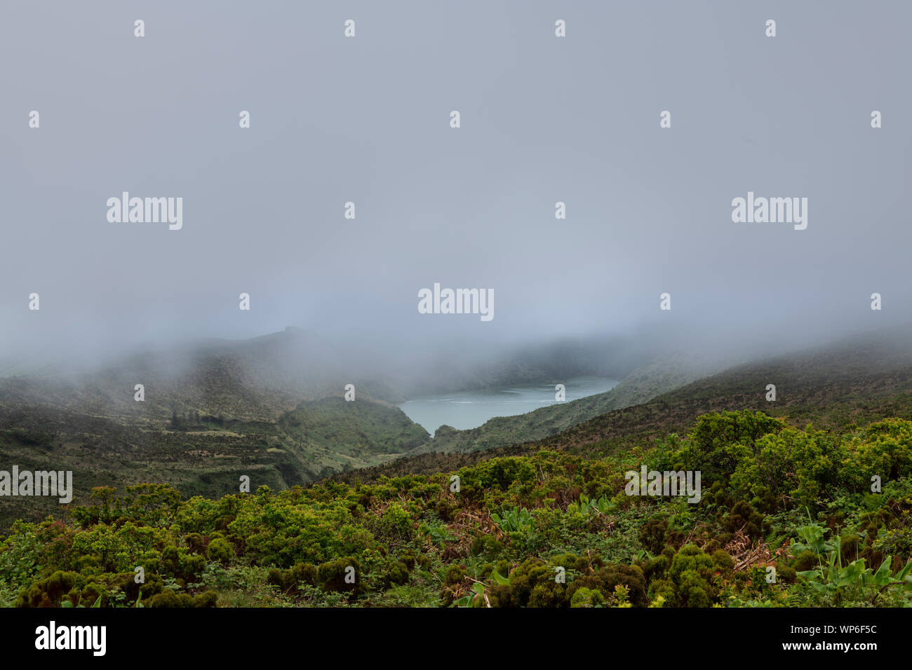 Paysage de nuages bas et de mauvaises conditions météo de Lagoa Funda das Lajes caldeira cratère volcanique lac à Ilha das Flores island dans les Açores, Portugal Banque D'Images