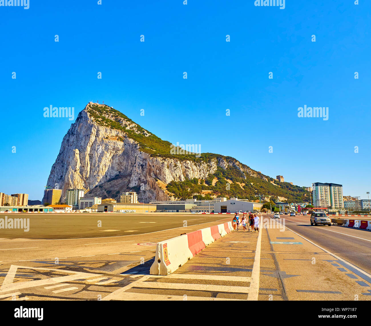 Les sections locales et les voitures traversant la piste à l'aéroport de Gibraltar avec le Rocher de Gibraltar dans l'arrière-plan. Gibraltar, Royaume-Uni. Banque D'Images