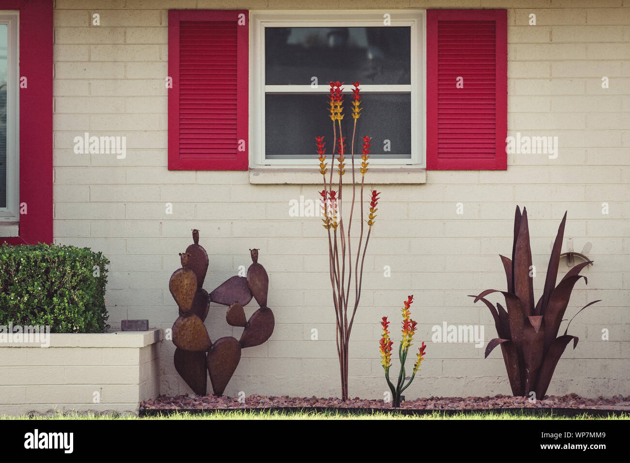 Détail analogique photo d'une maison en brique blanche aux volets rouges autour des fenêtres et d'un décor de cour lunatique à Sun City, Arizona. Banque D'Images