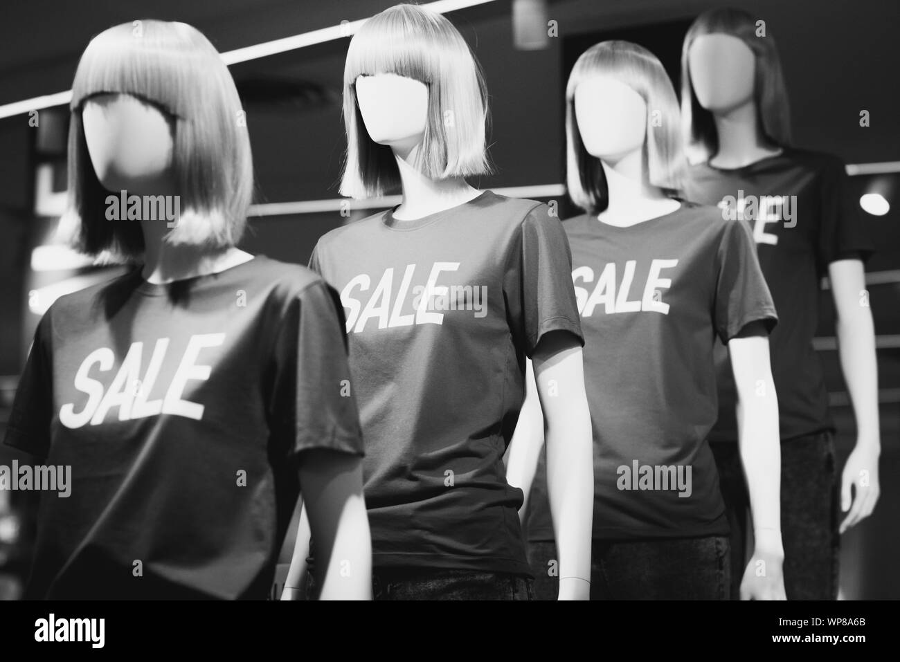 Les mannequins en T-shirts avec l'inscription 'sale' annonce de réductions dans un centre commercial. Photo en noir et blanc. Banque D'Images