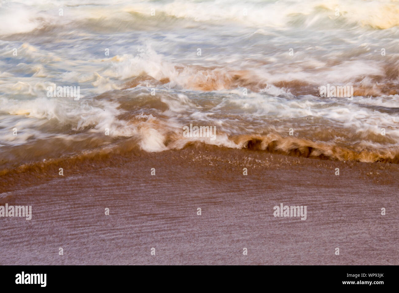 Après-midi forte marée, marée avec des vagues se brisant sur les rochers sur les rochers avec de fortes vagues écumeuses, un ressac, un lavage de côté. Du vrai en colère les vagues. Banque D'Images