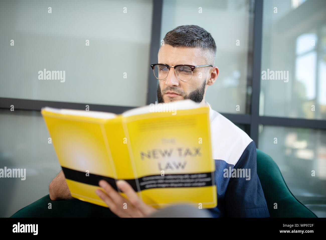 Close up of smart businessman reading nouveau livre Droit fiscal Banque D'Images