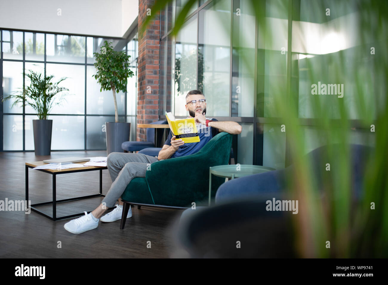 Sentiment d'affaires très occupé lors de la lecture de livre sur le droit fiscal Banque D'Images