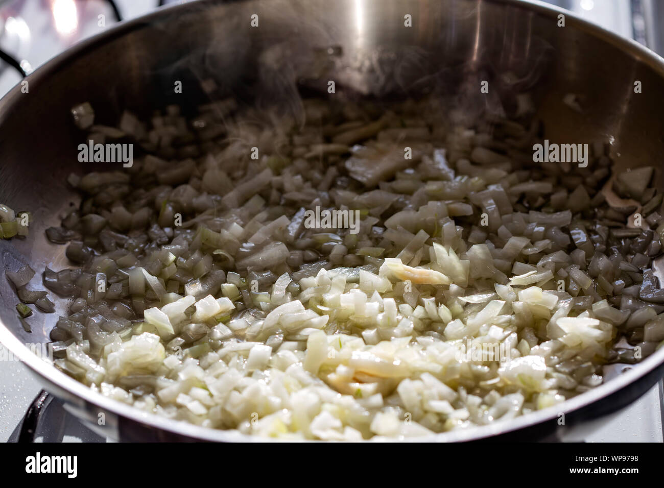Faire frire l'oignon haché dans une poêle avec de l'huile d'olive Banque D'Images