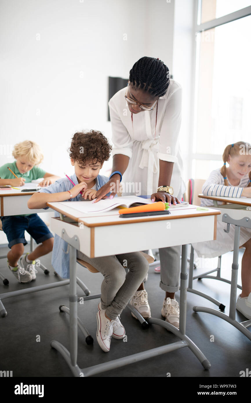 Professeur d'origine afro-américaine de venir à mignon garçon frisé Banque D'Images