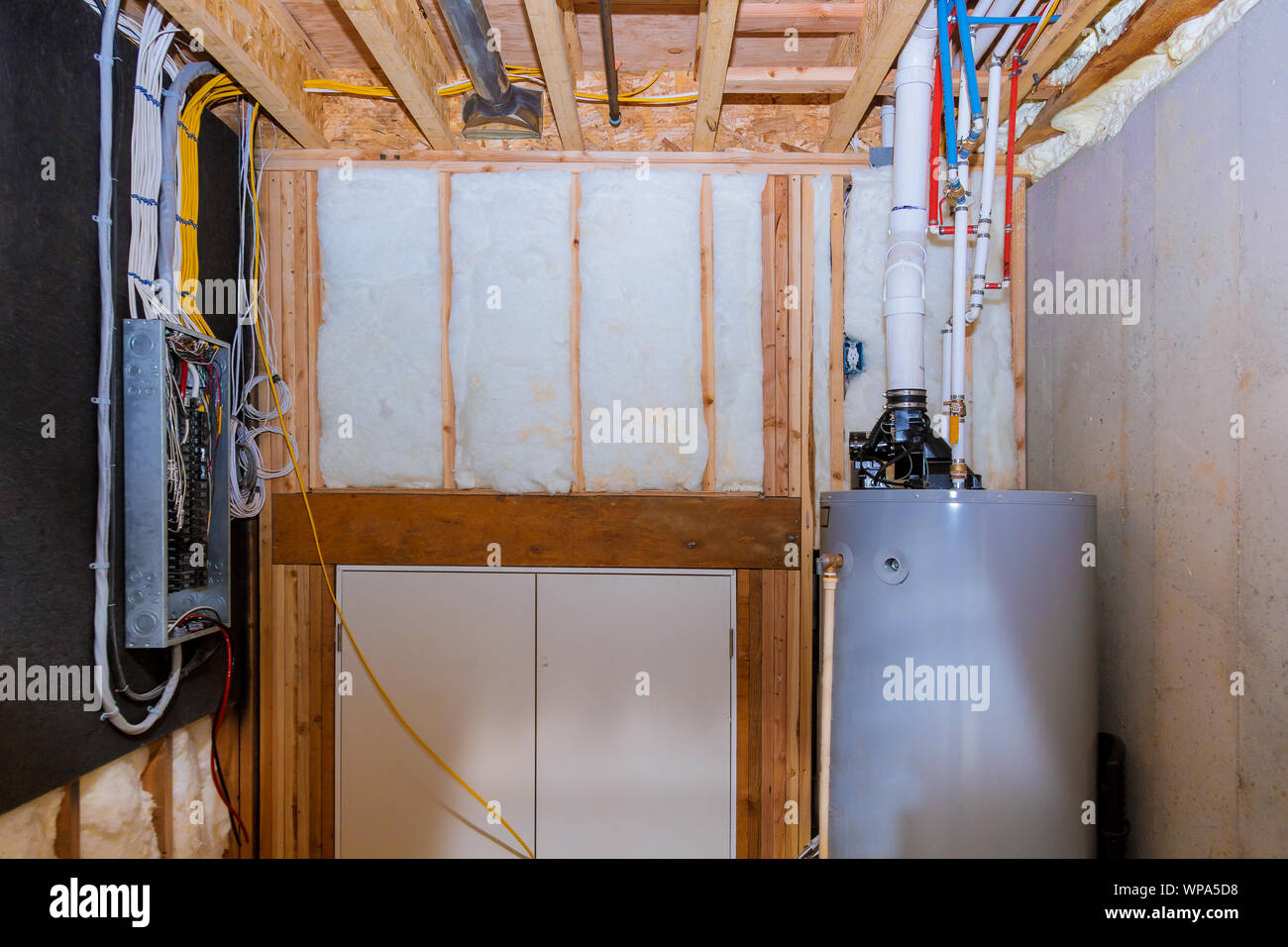 Les tuyaux de la chaudière et du système de chauffage d'une maison ossature bois avec sous-sol, panneau de câblage avec des câbles électriques dans les bornes Banque D'Images