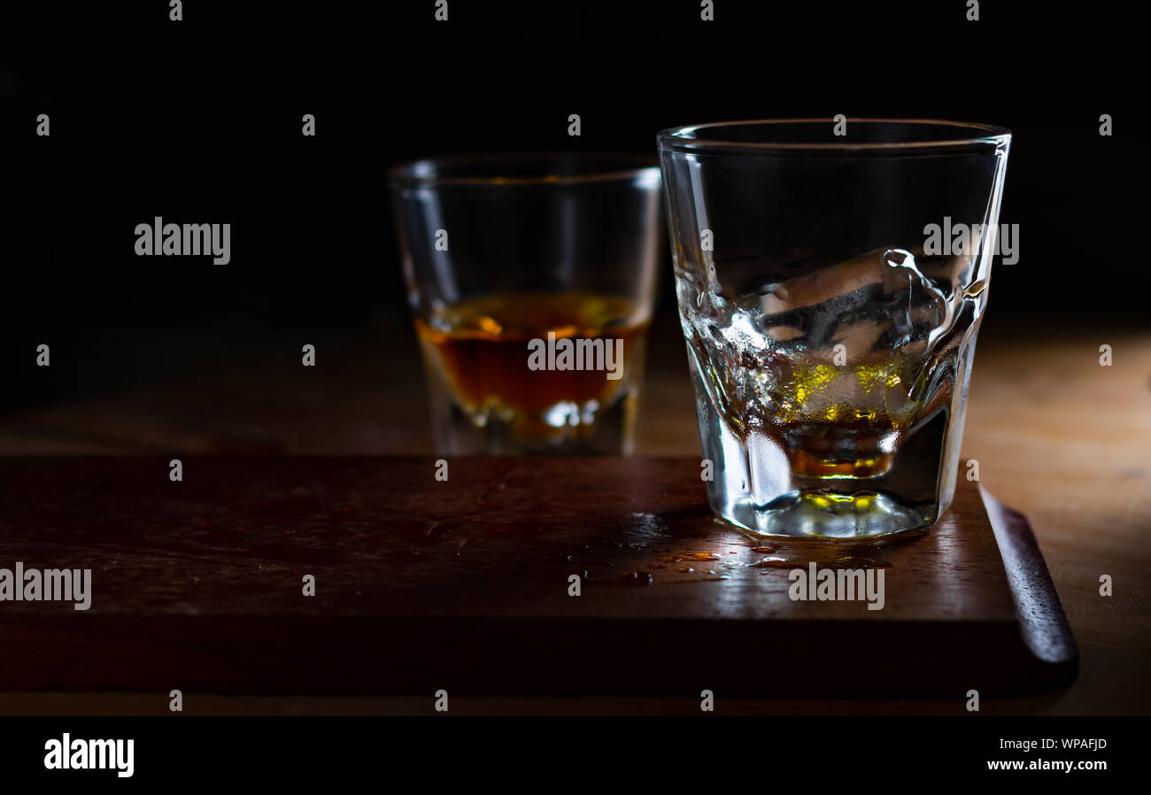 La glace dans un verre de whisky vide Banque D'Images