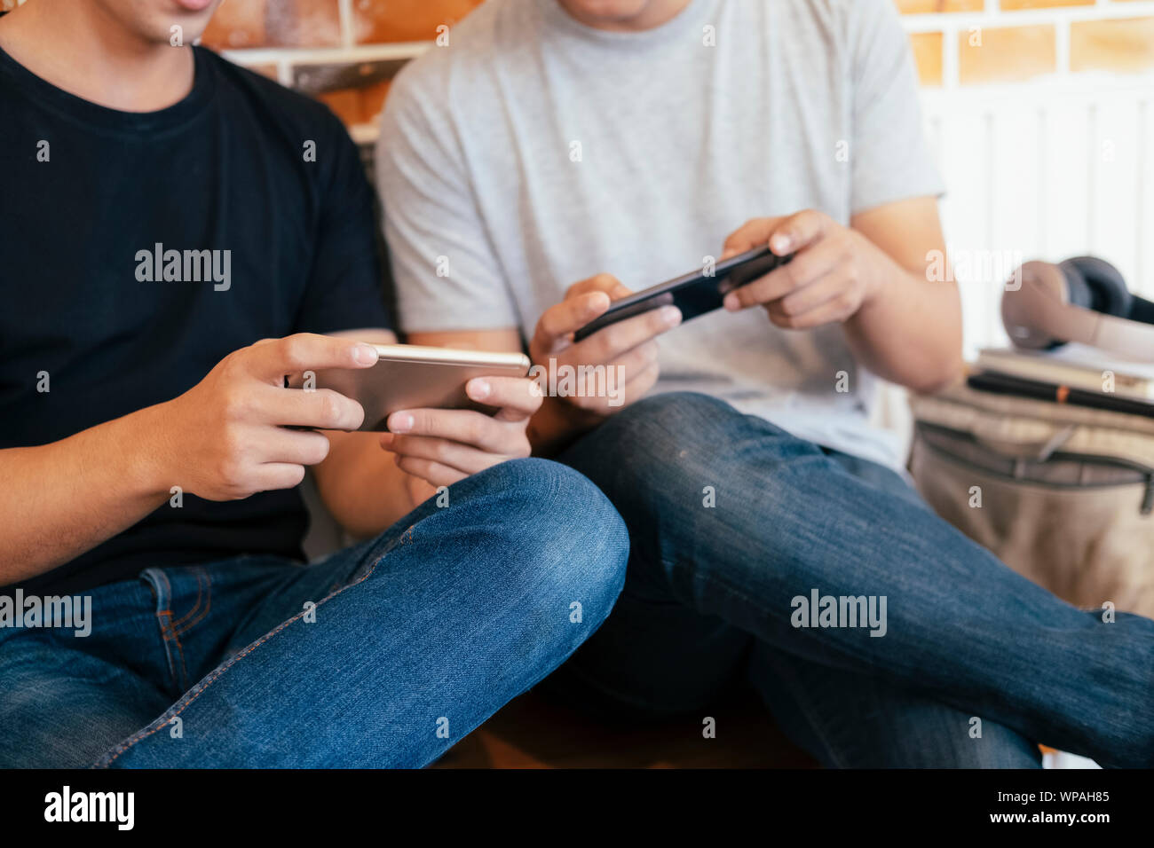 Подросток с телефоном. Играющий мужчина в телефон. Смартфон парень shutterstock. Играющий мужчина в телефон. Парень с двумя телефонами.