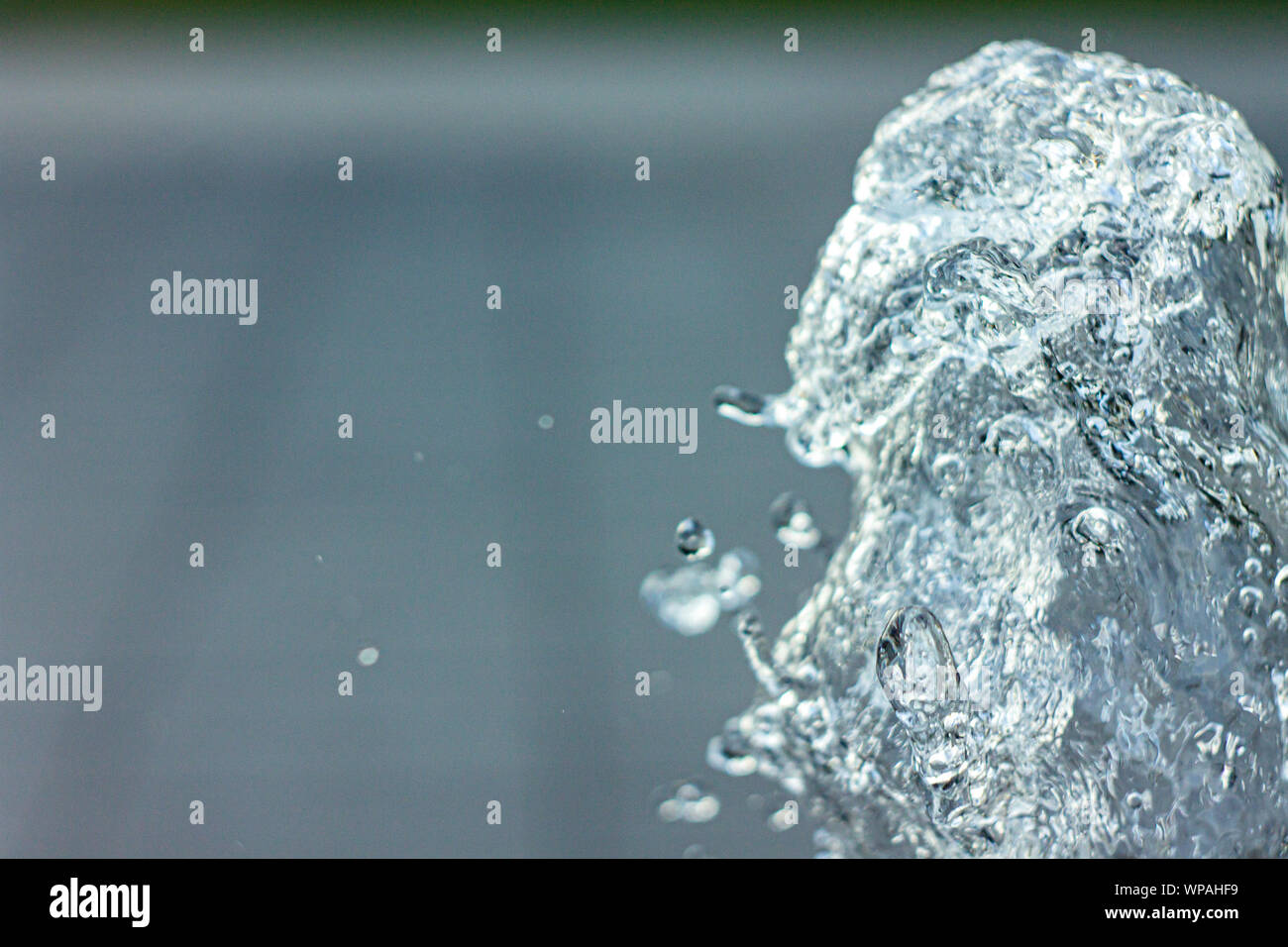 La sculpture de l'eau. Les éclaboussures de la fontaine en vol avec des gouttelettes avec origines floues Copyspace Banque D'Images