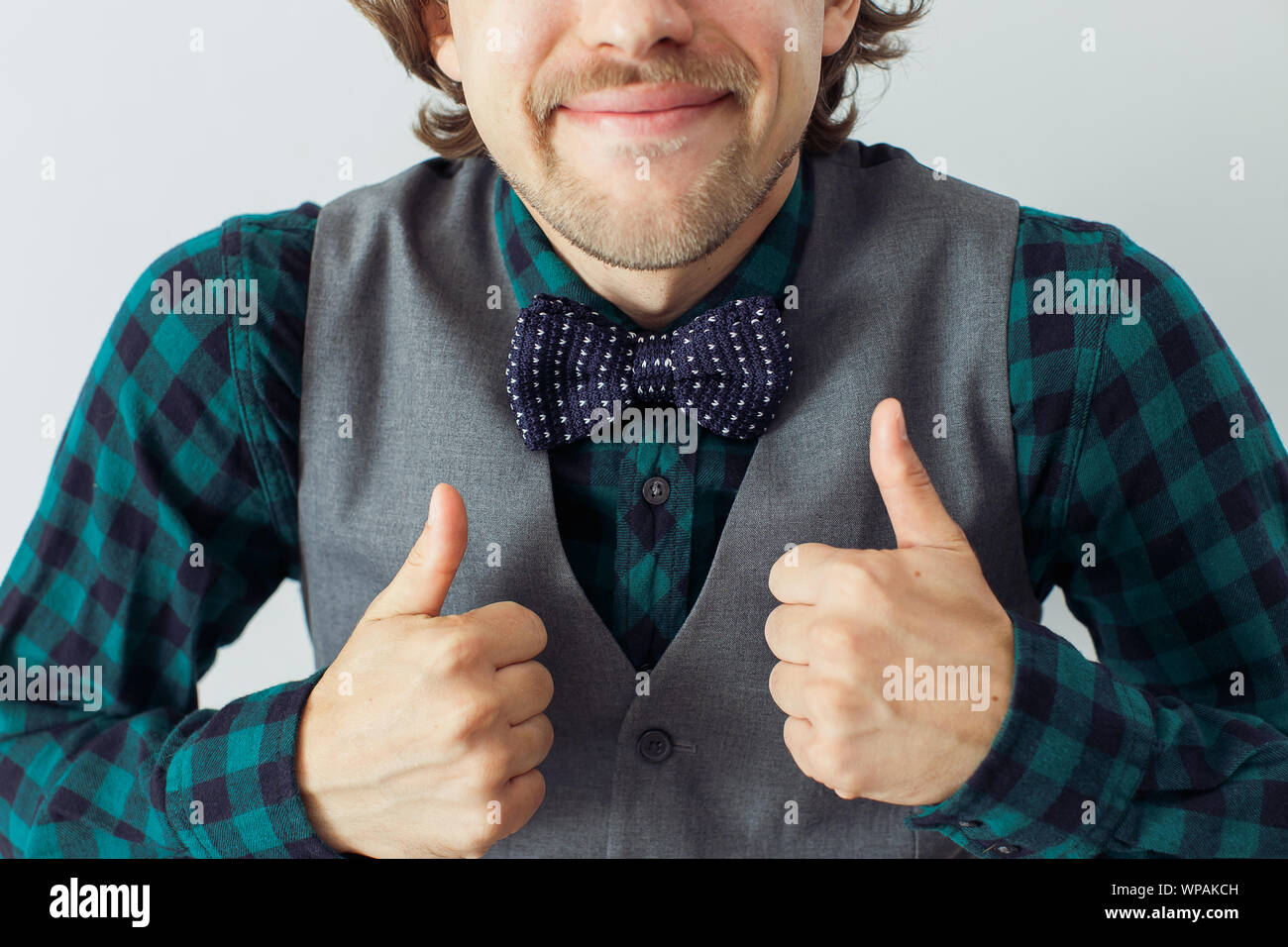 Homme avec barbe portant bowtie avec geste émotif, style hippie Banque D'Images